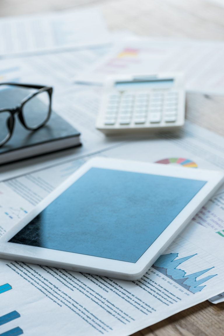 selective focus of digital tablet near notebook and glasses on papers